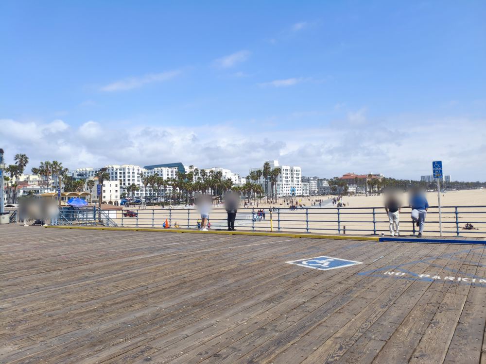Plancher en bois de la jetée de Santa Monica avec vue sur la plage et les palmiers